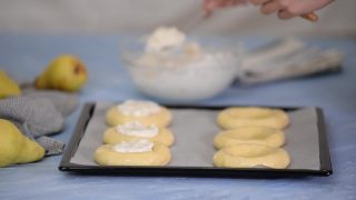 一个女人用奶油芝士和梨做圆面包。视频素材模板下载
