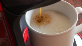 胶囊咖啡机或咖啡机制作早晨拿铁咖啡和倒牛奶到杯子。在家煮咖啡和倒咖啡的过程视频素材模板下载