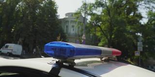 警车在城市街道的车顶上闪烁着红色和蓝色的警笛