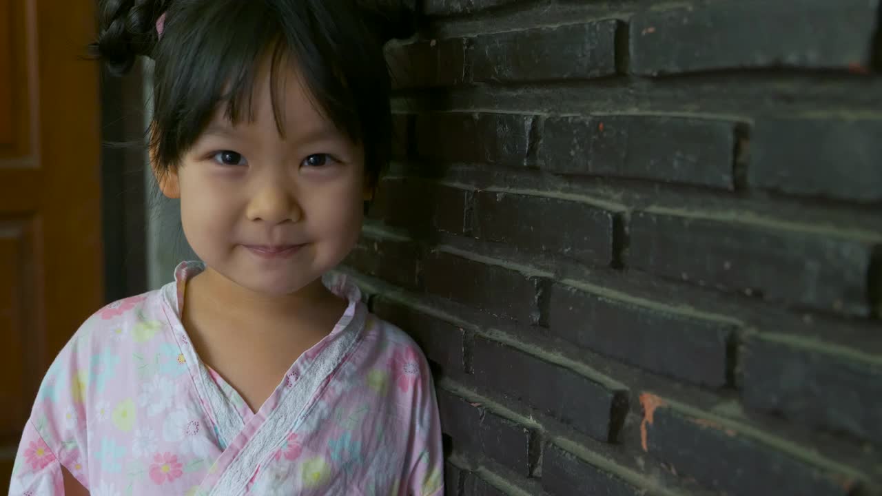 穿着粉红色日本连衣裙的亚洲女孩的肖像。