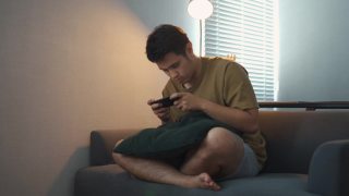 亚洲男人在玩手机游戏视频素材模板下载