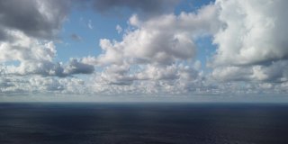 抽象的空气天空和移动的丰满的云在海洋。清澈见底的水面上的小浪从日出起。假日、度假和休闲的概念