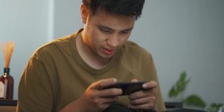 亚洲男人在玩手机游戏