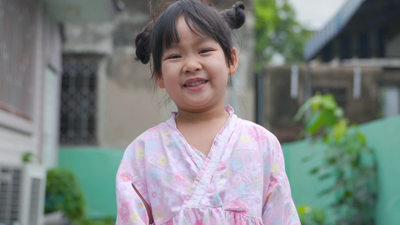 穿着粉红色日本连衣裙的亚洲女孩的肖像。