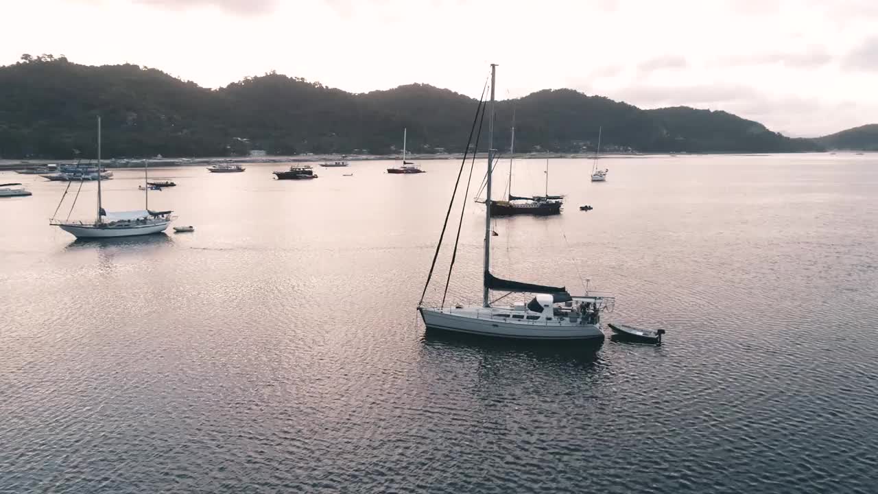 无人机拍摄的船只停泊在海湾与清澈和蓝绿色的水在日落。小船和游艇在热带泻湖。热带景观。El Nido，巴拉望岛，菲律宾。