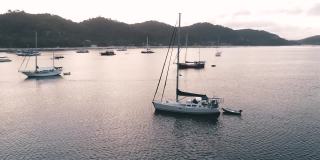 无人机拍摄的船只停泊在海湾与清澈和蓝绿色的水在日落。小船和游艇在热带泻湖。热带景观。El Nido，巴拉望岛，菲律宾。