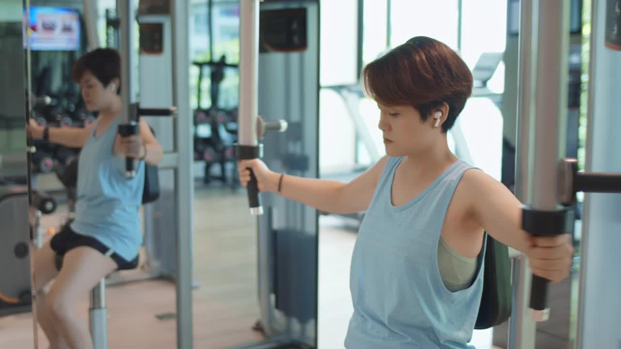 SLO MO健身女人在健身房用健身器进行锻炼，多莉拍摄