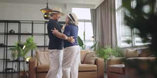 幸福退休亚洲人爱夫妇退休老夫妇在家，亚洲老夫妇一起跳舞笑笑喜气在客厅在家隔离呆在家封锁概念