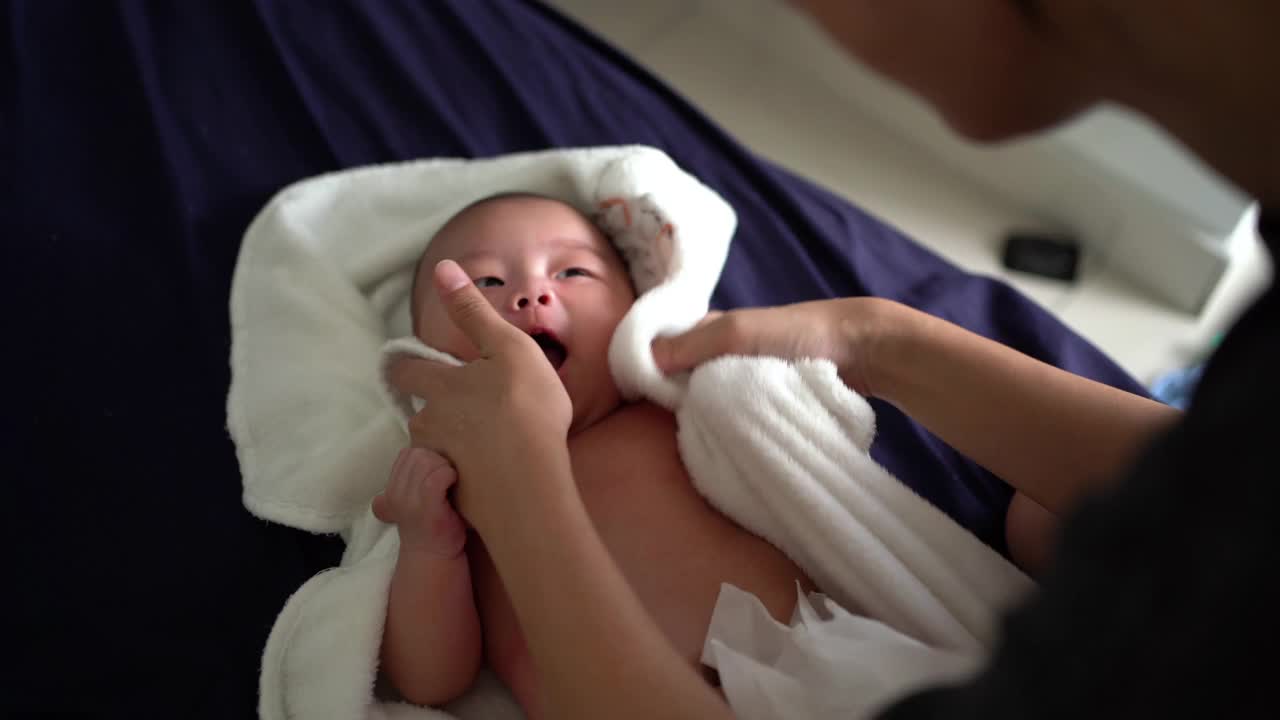 婴儿洗澡后，母亲用毛巾擦干身子