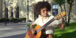 非裔美国女艺术家弹吉他和唱歌，街头表演