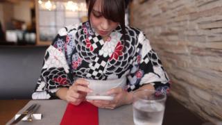 一名日本女子在汤田餐厅使用智能手机视频素材模板下载