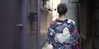 一位日本妇女走在一条狭窄的小径上