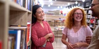亚洲种族的女性图书管理员帮助顾客找到和选择的书