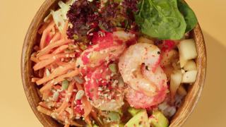 橙色背景的Poke碗沙拉。蔬菜切片，红鱼和芝麻。传统的夏威夷美食特写。健康的素食。亚洲素食生餐轮换视频素材模板下载
