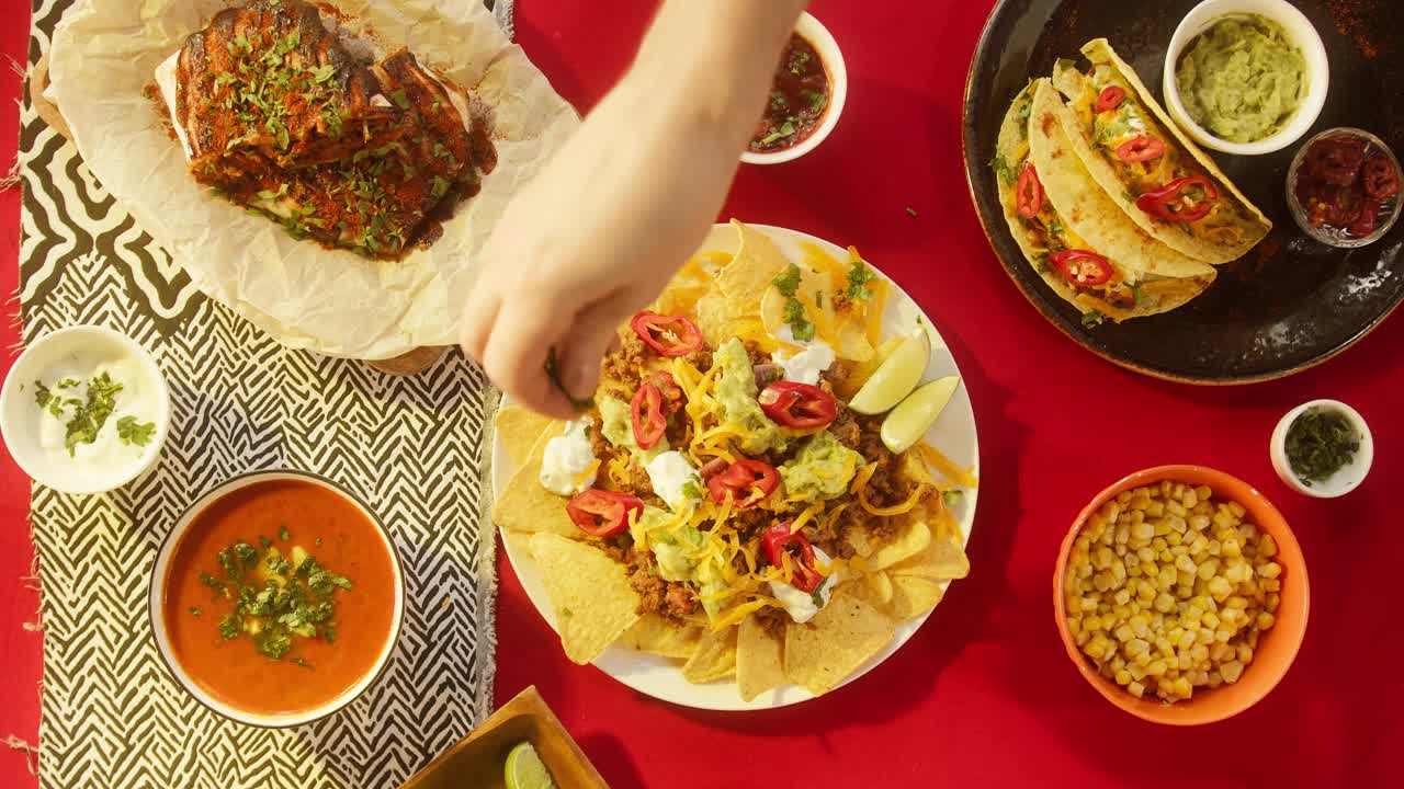 墨西哥食物，传统的墨西哥美食。在配肉和蔬菜的玉米片上放上绿色植物和榨酸橙汁。在餐桌上摆放美式菜肴