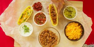 桌上的传统墨西哥食物，特克斯墨西哥美食。烹饪肉玉米卷或玉米煎饼，加入鳄梨酱。玉米和香菜番茄汤，酱汁碗。美式菜肴俯视图