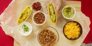 桌上的传统墨西哥食物，特克斯墨西哥美食。烹饪肉玉米卷或玉米煎饼，把番茄酱和香菜放在里面，鳄梨色拉酱。美式菜肴俯视图