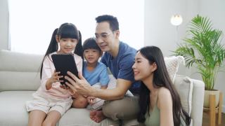 一家人一起在家里使用平板电脑。视频素材模板下载