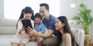 一家人一起在家里使用平板电脑。