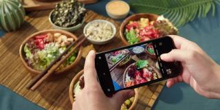 用智能手机特写拍摄夏威夷戳碗。由切成片的蔬菜、海鲜和绿叶植物制成的熟戳。健康的素食。亚洲素食生食，筷子