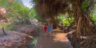 Slowmotion。在越南南部的梅尼村，一个家庭沿着沙漠边界的红色峡谷或仙女溪散步。用手机拍摄