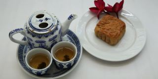 中国茶具，月饼和红色花朵，自然光线，背景