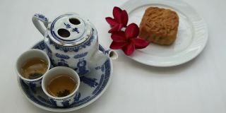 中国茶具，月饼和红色花朵，自然光线，背景
