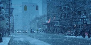 在暴风雪中的城市，汽车和人在晚上