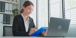 亚洲商界女性人力资源经理在线视频面试。迷人的女上班族在工作场所用笔记本电脑和工作人员通过虚拟会议进行交流。