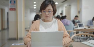 亚洲女人在图书馆用笔记本电脑
