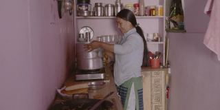 一位中年的亚洲印度农村妇女在家里端着一盘煮熟的热馍馍