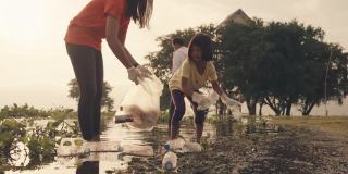 亚洲志愿者家庭晚上在河边收集塑料瓶和水葫芦。