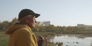 正退休的老人享受秋天的城市公园，休息时喝咖啡