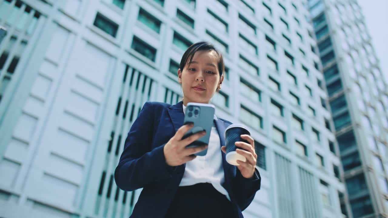 亚洲女商人在城市使用手机