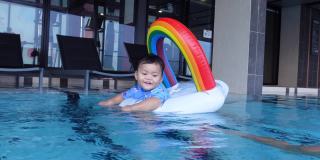 亚洲男婴和妈妈一起在游泳池里学游泳