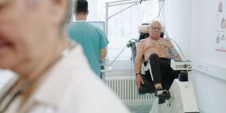 老年男性患者在静态自行车上进行心脏压力测试