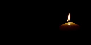 燃烧的蜡烛孤立在黑色背景火焰在风中移动图片的右侧