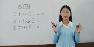 亚洲女教师在教室里教学生。