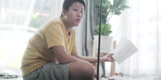 亚洲男孩在家组装从网上买的新电灯，男孩自己打结。