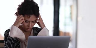 压力重重的女商人坐着工作，带着笔记本电脑。执行女主任感到工作严重和担心，商人来安抚同事们从困难问题中恢复过来。