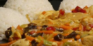 美味的亚洲食物，煮熟的米饭在盘子里慢慢旋转，里面装满了蔬菜