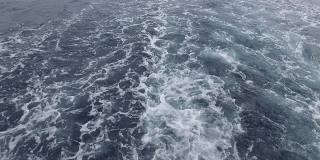 船在海洋里。海浪从渡船的后面掠过水面。有泡沫痕迹的船背景与波。大自然。