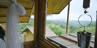 亚洲妇女在木屋度假胜地的窗边看自然风景