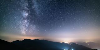 繁星点点的夜空在山间天文时光流逝，银河的星星在乡村的交通上移动