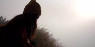 一个女旅行者站在山顶看日出的慢镜头