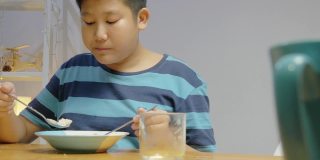 快乐的亚洲孩子在家里一起享受晚餐，简单的生活理念。