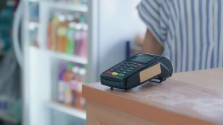 使用信用卡付款的客户。客户使用非接触式信用卡付款，柜台设有读卡机。通过NFC技术接受付款的收银员。视频素材模板下载