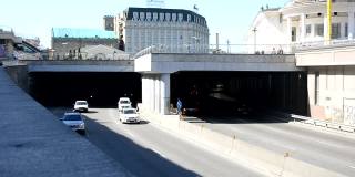 乌克兰基辅——2021年4月24日:汽车离开隧道并进入隧道。楼上有一个供游客步行的广场