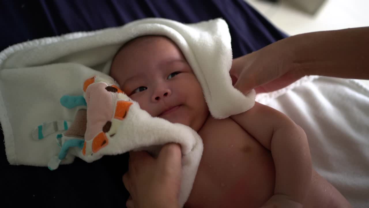 婴儿洗澡后，母亲用毛巾擦干身子
