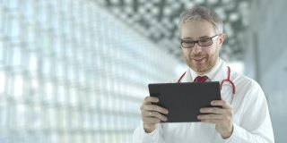 医生使用他的平板电脑与病人进行远程医疗交流。用红色相机拍摄